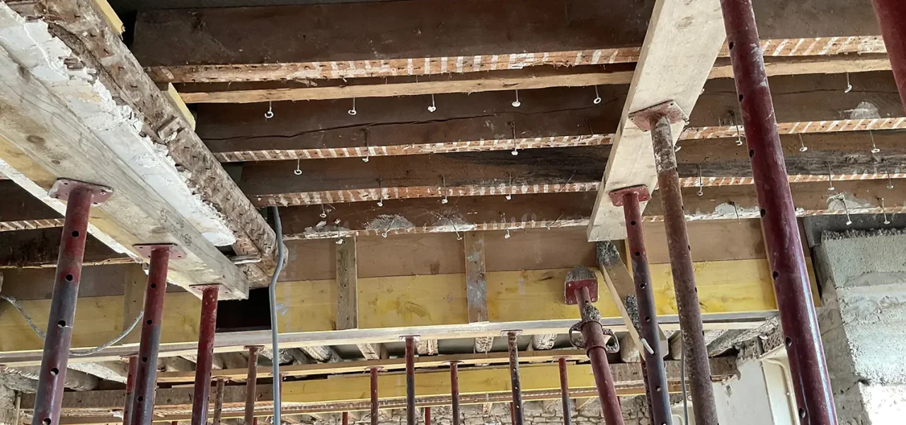 Structure de plancher en rénovation avec poutres apparentes et étayage métalliqu